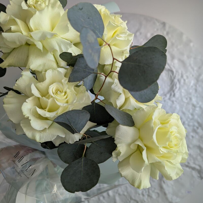 Белые розы с эвкалиптом в упаковке